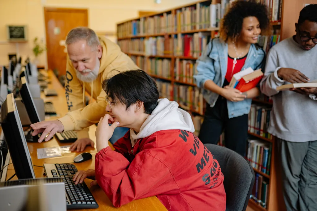 4 pessoas em uma biblioteca universitária.
