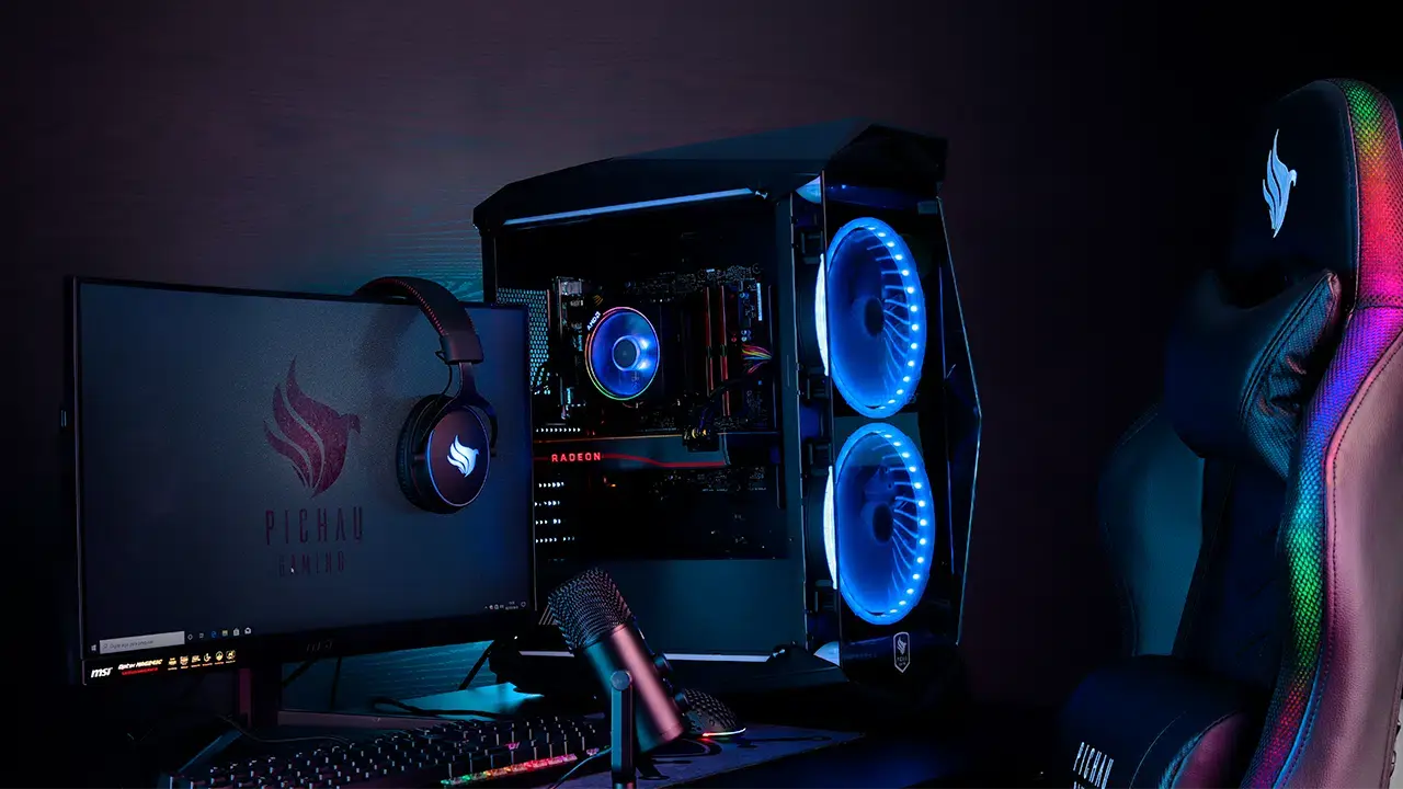 PC gamer Mancer com iluminação RGB, monitor, headset, microfone e cadeira gamer em um setup.