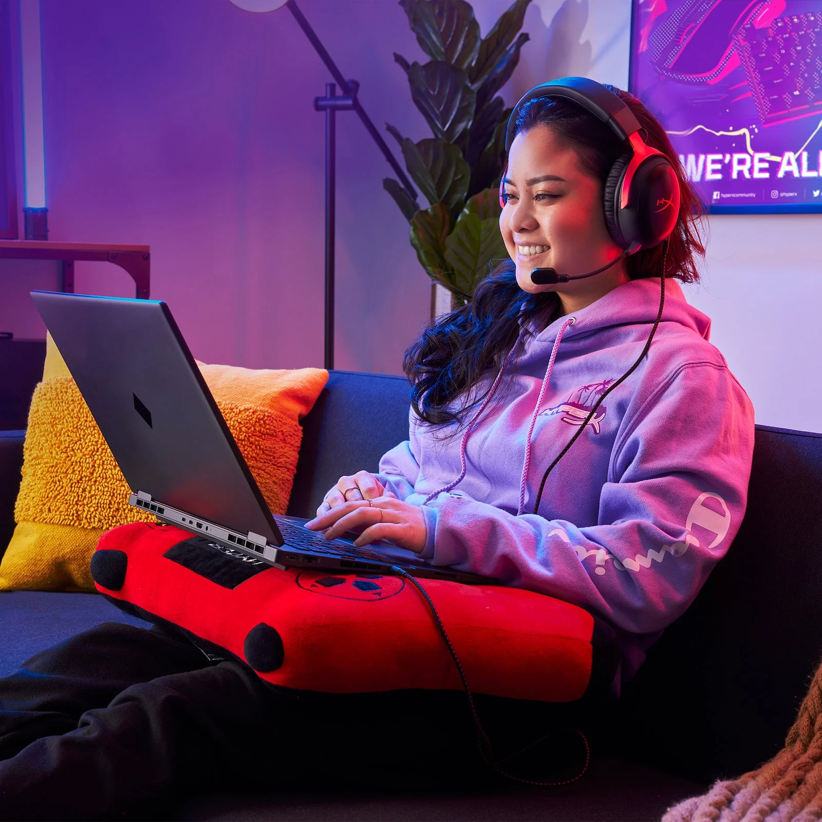 Cinco headsets gamer para PC, PS5 e Xbox: como escolher o ideal para você Pessoa usa um HyperX Cloud III com fio preto e vermelho enquanto joga em um notebook no sofá.